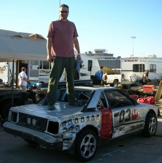 larry standing on his beat up MR2